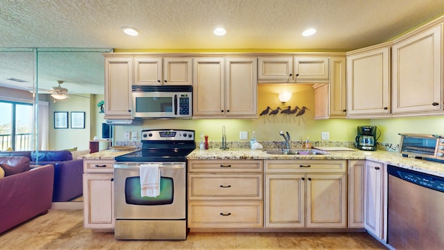 kitchen with stainless steel appliances, sink, ceiling fan, and a textured ceiling