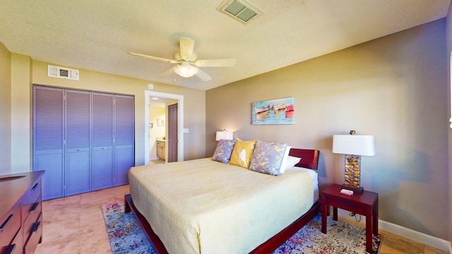 tiled bedroom featuring ceiling fan, a closet, and ensuite bath