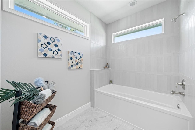 bathroom with tile floors and tiled shower / bath combo