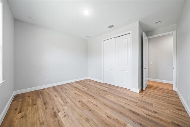 unfurnished bedroom featuring a closet and light hardwood / wood-style flooring