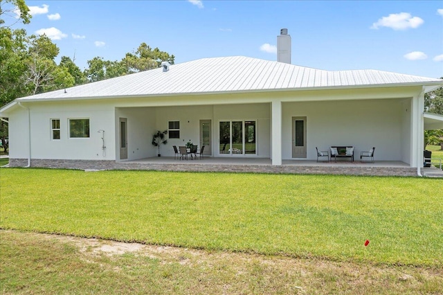 rear view of property with a yard and a patio