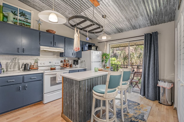 kitchen featuring white appliances, hanging light fixtures, backsplash, and light hardwood / wood-style flooring