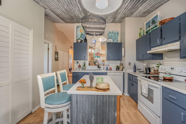 kitchen with a kitchen island, backsplash, blue cabinets, light wood-type flooring, and white appliances