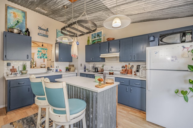 kitchen featuring a center island, light wood-type flooring, white appliances, backsplash, and blue cabinets