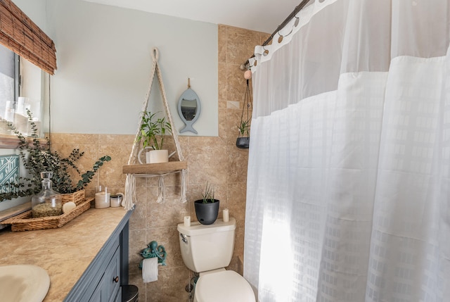 bathroom with vanity, toilet, and tile walls