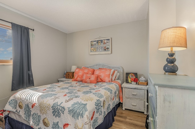 bedroom featuring light hardwood / wood-style floors and a textured ceiling