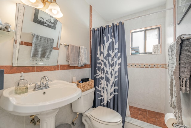 bathroom featuring tile flooring, tasteful backsplash, tile walls, sink, and toilet