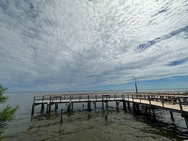 view of dock featuring a view of the beach and a water view