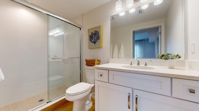 bathroom with a shower with door, large vanity, and toilet