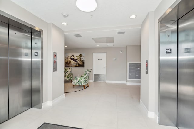 corridor with elevator and light tile floors