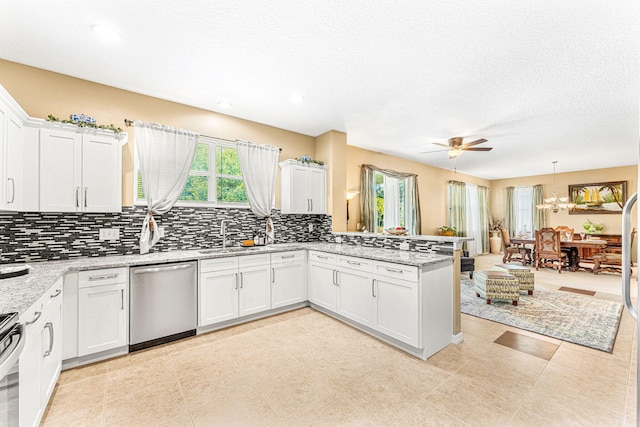 kitchen featuring kitchen peninsula, stainless steel appliances, ceiling fan, white cabinets, and hanging light fixtures