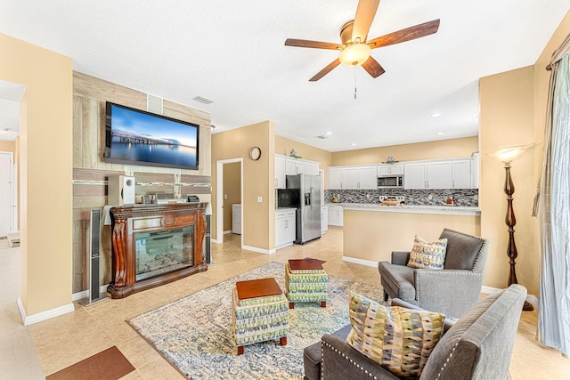 tiled living room featuring ceiling fan and a textured ceiling