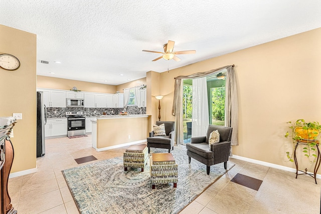 tiled living room with ceiling fan and a textured ceiling