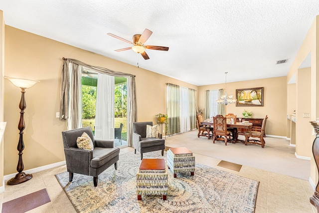 living room with ceiling fan, light tile patterned flooring, and a textured ceiling