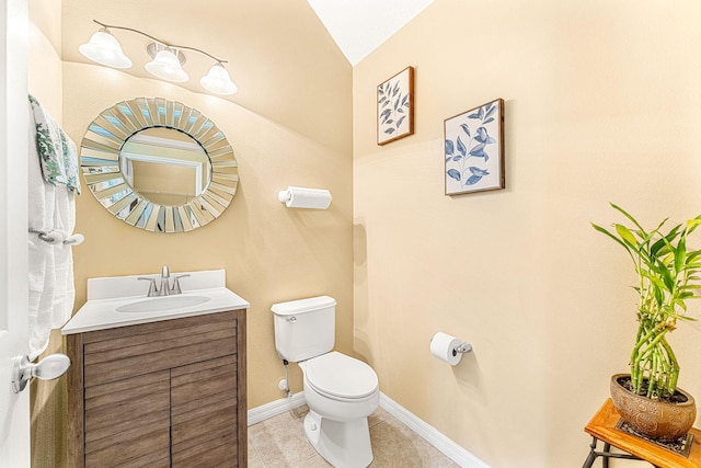 bathroom with tile patterned flooring, vanity, lofted ceiling, and toilet