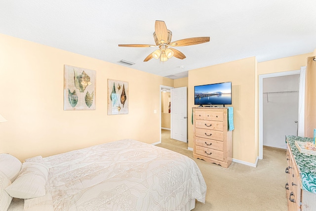 carpeted bedroom with ceiling fan, a spacious closet, and a closet