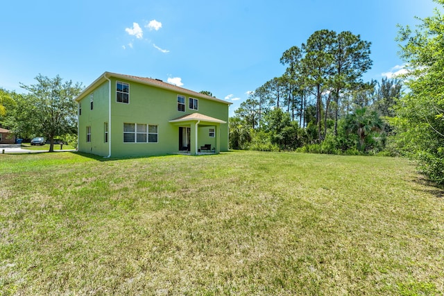 back of house with a lawn