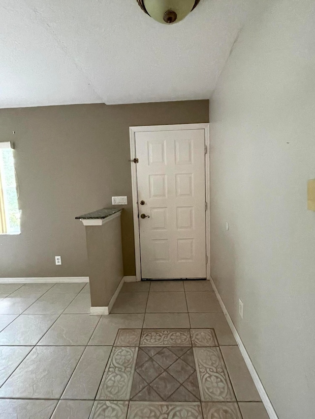 doorway to outside with light tile patterned floors