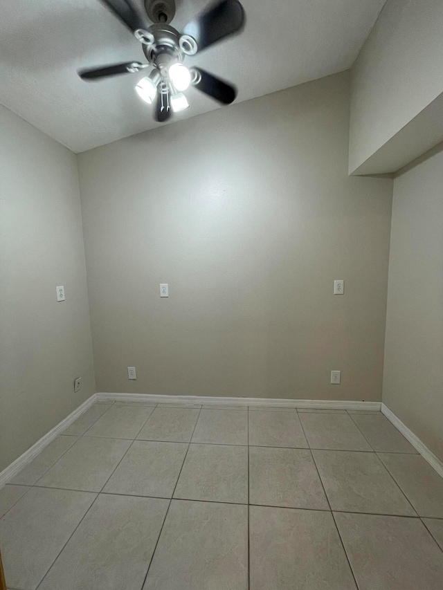 tiled spare room featuring ceiling fan