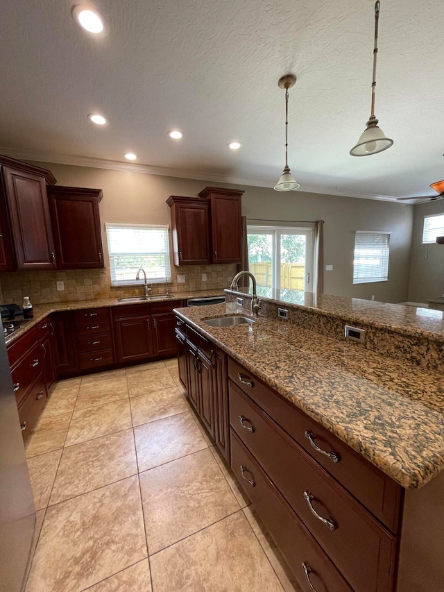 kitchen with light tile patterned flooring, decorative light fixtures, tasteful backsplash, and sink