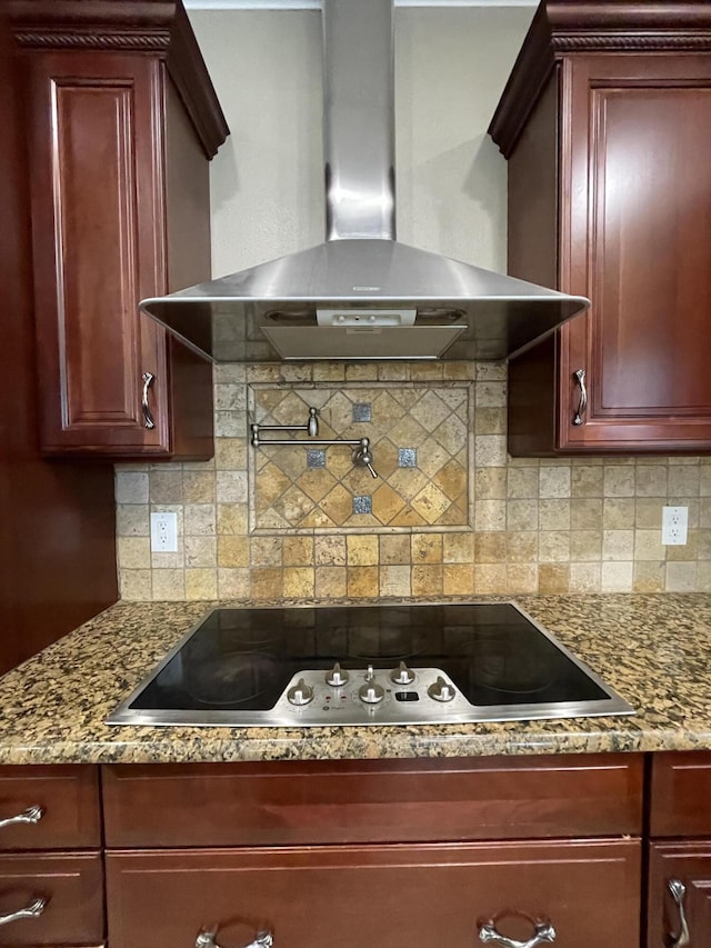 kitchen featuring decorative backsplash, stone counters, black electric cooktop, dark brown cabinets, and wall chimney range hood