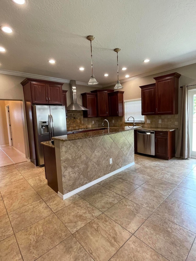 kitchen featuring pendant lighting, a center island, decorative backsplash, stainless steel appliances, and wall chimney exhaust hood