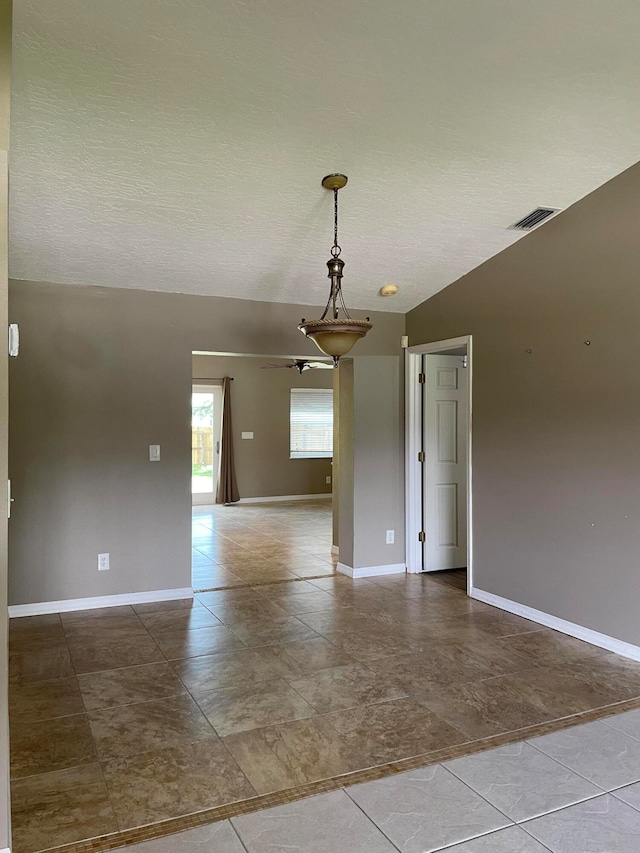 empty room featuring lofted ceiling and a textured ceiling