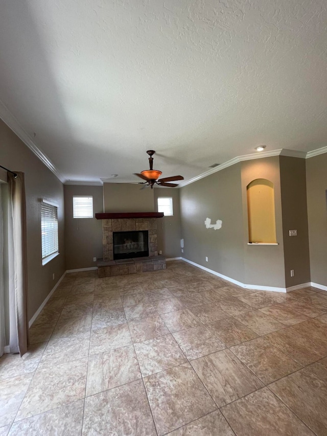 unfurnished living room with ceiling fan, tile patterned flooring, a stone fireplace, and ornamental molding