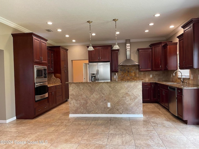 kitchen featuring decorative light fixtures, a center island, sink, appliances with stainless steel finishes, and wall chimney exhaust hood