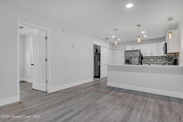 702 S Myrtle Ave, New Smyrna Beach, FL 32168 - kitchen featuring white cabinetry, wood finished floors, a peninsula, and stainless steel appliances
