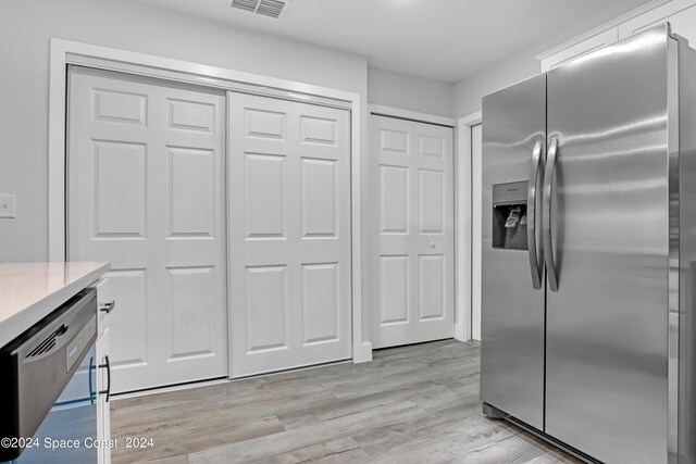 702 S Myrtle Ave, New Smyrna Beach, FL 32168 - kitchen featuring light countertops, stainless steel fridge with ice dispenser, dishwasher, light wood-style flooring, and visible vents