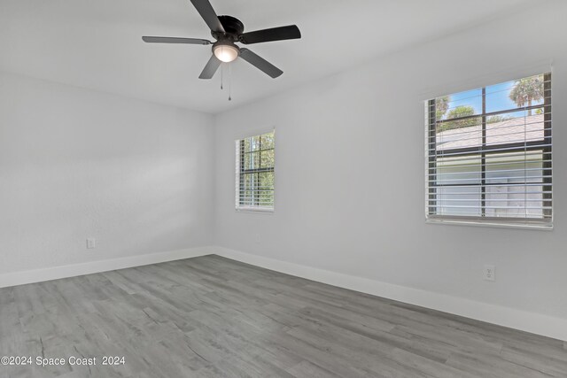 702 S Myrtle Ave, New Smyrna Beach, FL 32168 - empty room featuring baseboards, wood finished floors, and a ceiling fan