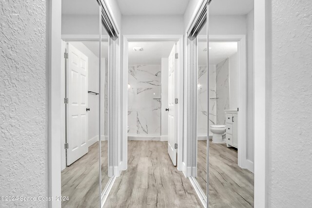 702 S Myrtle Ave, New Smyrna Beach, FL 32168 - hallway featuring baseboards, a textured wall, and wood finished floors
