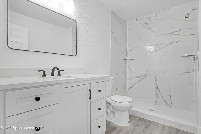 702 S Myrtle Ave, New Smyrna Beach, FL 32168 - full bath with a textured wall, wood finished floors, vanity, and a marble finish shower