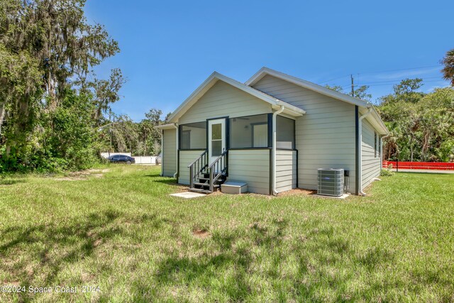 702 S Myrtle Ave, New Smyrna Beach, FL 32168 - rear view of property featuring entry steps, central AC, and a yard