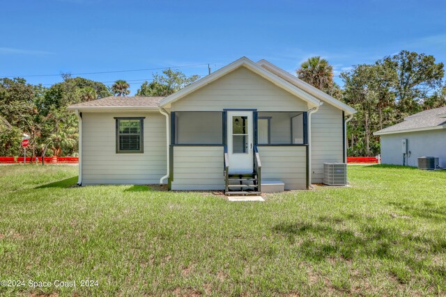 702 S Myrtle Ave, New Smyrna Beach, FL 32168 - view of front of home featuring central AC unit, entry steps, a front lawn, and roof with shingles