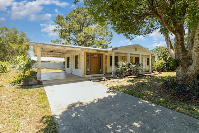 single story home featuring a carport, a porch, and a front yard