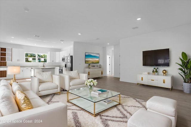 living room with light hardwood / wood-style floors and sink