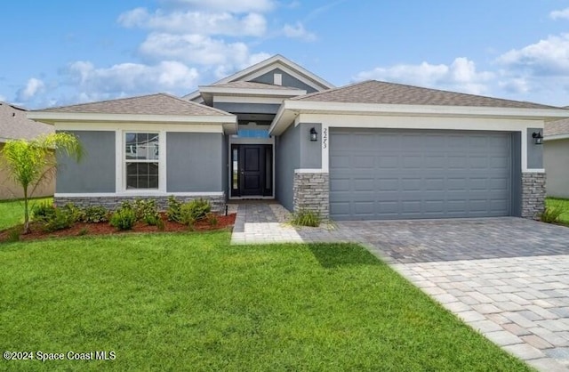 view of front of property featuring a garage, stone siding, decorative driveway, stucco siding, and a front lawn