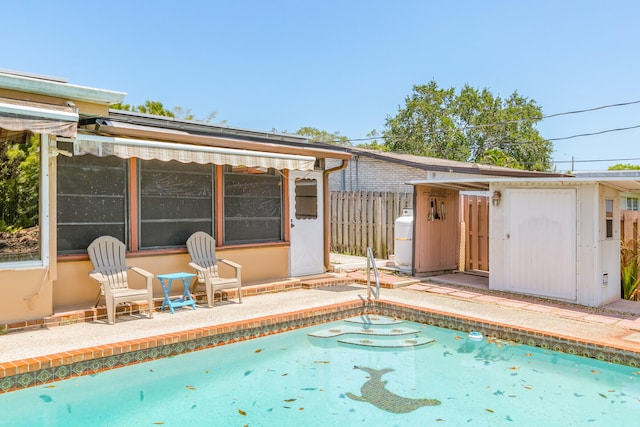 view of swimming pool featuring an outdoor structure and a patio