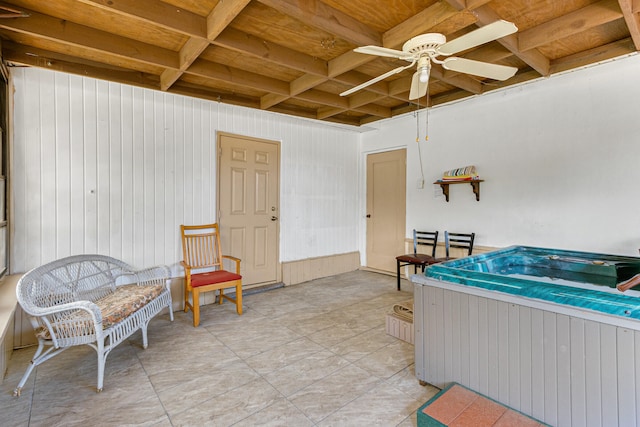 interior space featuring beamed ceiling, wood ceiling, and ceiling fan