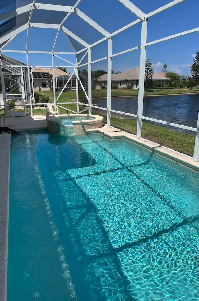 view of swimming pool with a lanai, an in ground hot tub, and a water view