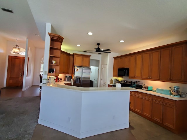 kitchen with ceiling fan with notable chandelier, kitchen peninsula, and stainless steel appliances