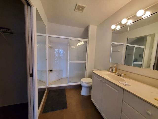 bathroom featuring tile patterned floors, vanity, toilet, and an enclosed shower