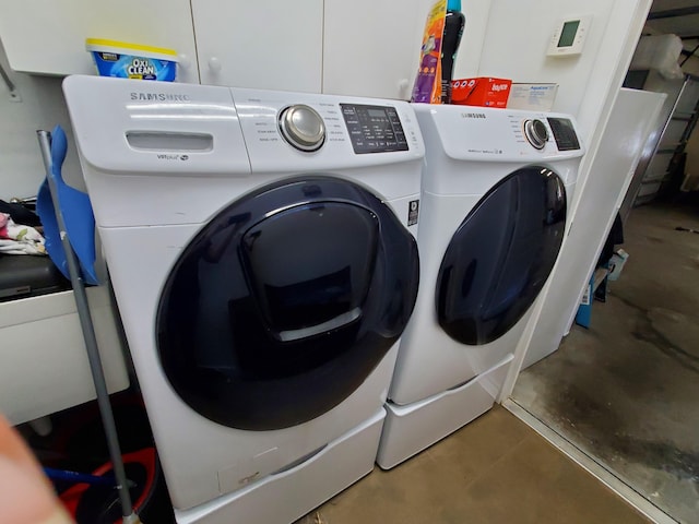 clothes washing area with washing machine and dryer