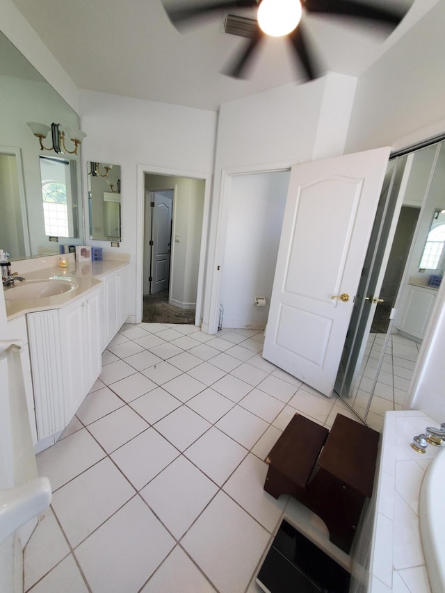 bathroom featuring tile patterned flooring, vanity, ceiling fan, and a bathing tub