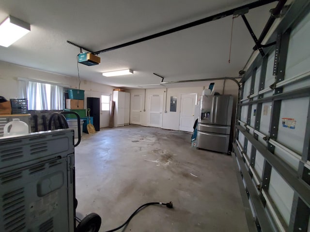 garage featuring stainless steel fridge, electric panel, and a garage door opener