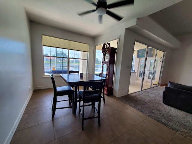 tiled dining space featuring ceiling fan