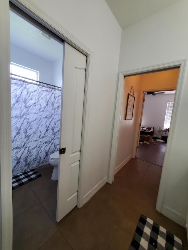 hallway with dark tile patterned flooring