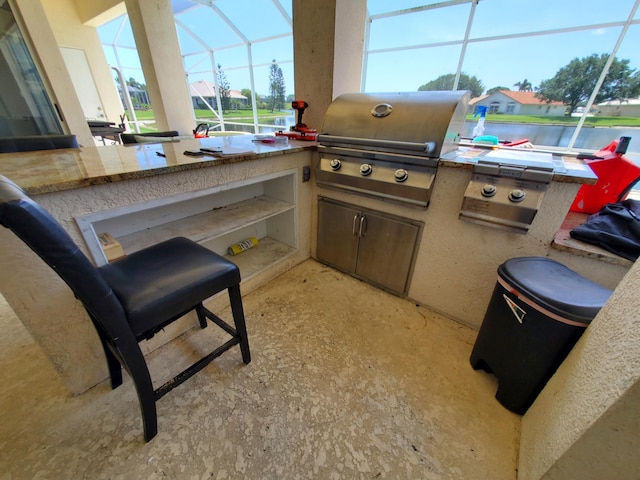 view of patio / terrace featuring a grill, a lanai, and exterior kitchen